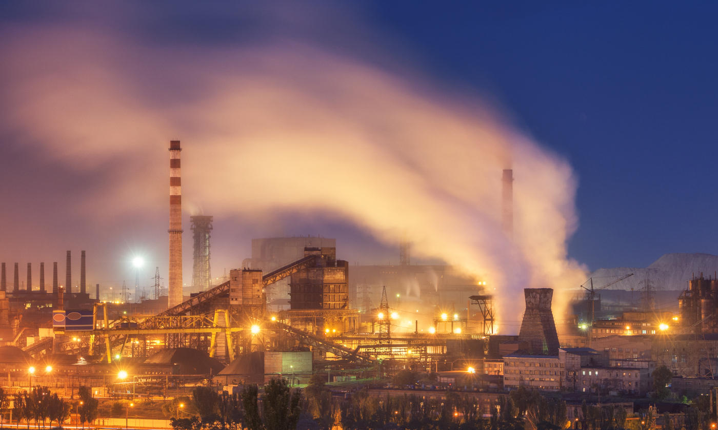 Metallurgical plant at night. Steel factory with smokestacks. Steelworks, iron works. Heavy industry in Europe. Air pollution from smokestacks, ecology problems. Industrial landscape at dusk. Plant